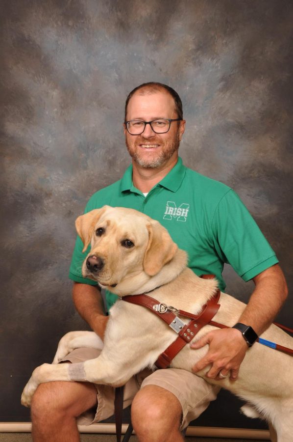 Peter McConnell, theology teacher, had his picture taken with service dog, Elroy at the beginning of the 2019-20 school year. McConnell acquired  Elroy as a seeing eye dog during the summer.  