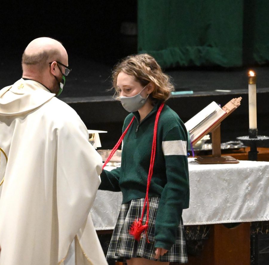 Father+Danny+Grover+presents+the+red+cord+to+senior+Maddie+Rowlan+at+the+April+27+Mass.