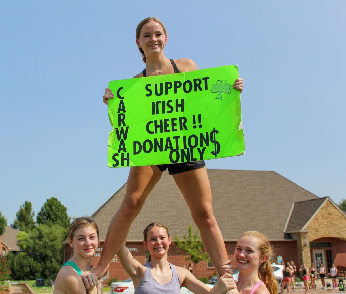 Avery Mcintire (10) flys in the air to get cars passing by to come get a car wash.