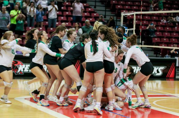 The team celebrating in the middle of the court after winning the championship.