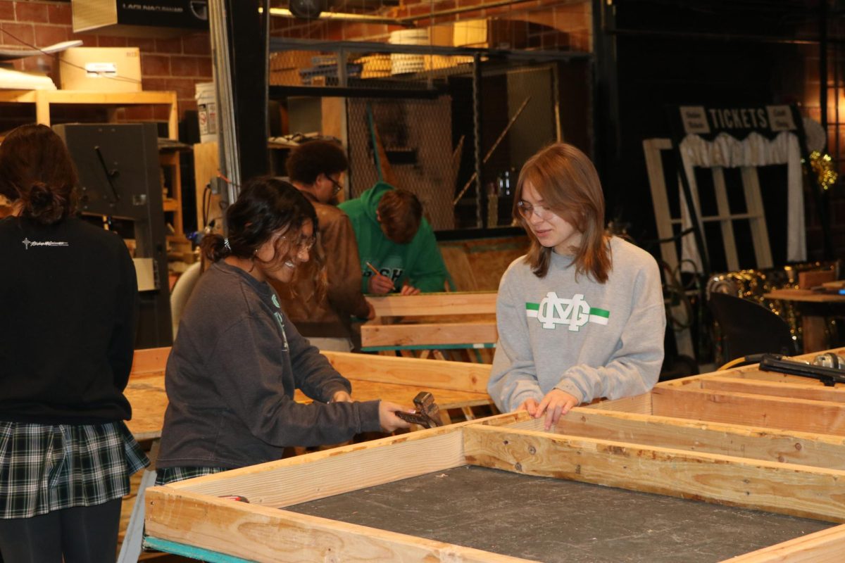 Sophomores Suri Huaman and Emelia Chambers hammer nails during stage craft class. The structure will be used on the set of ‘Clue’