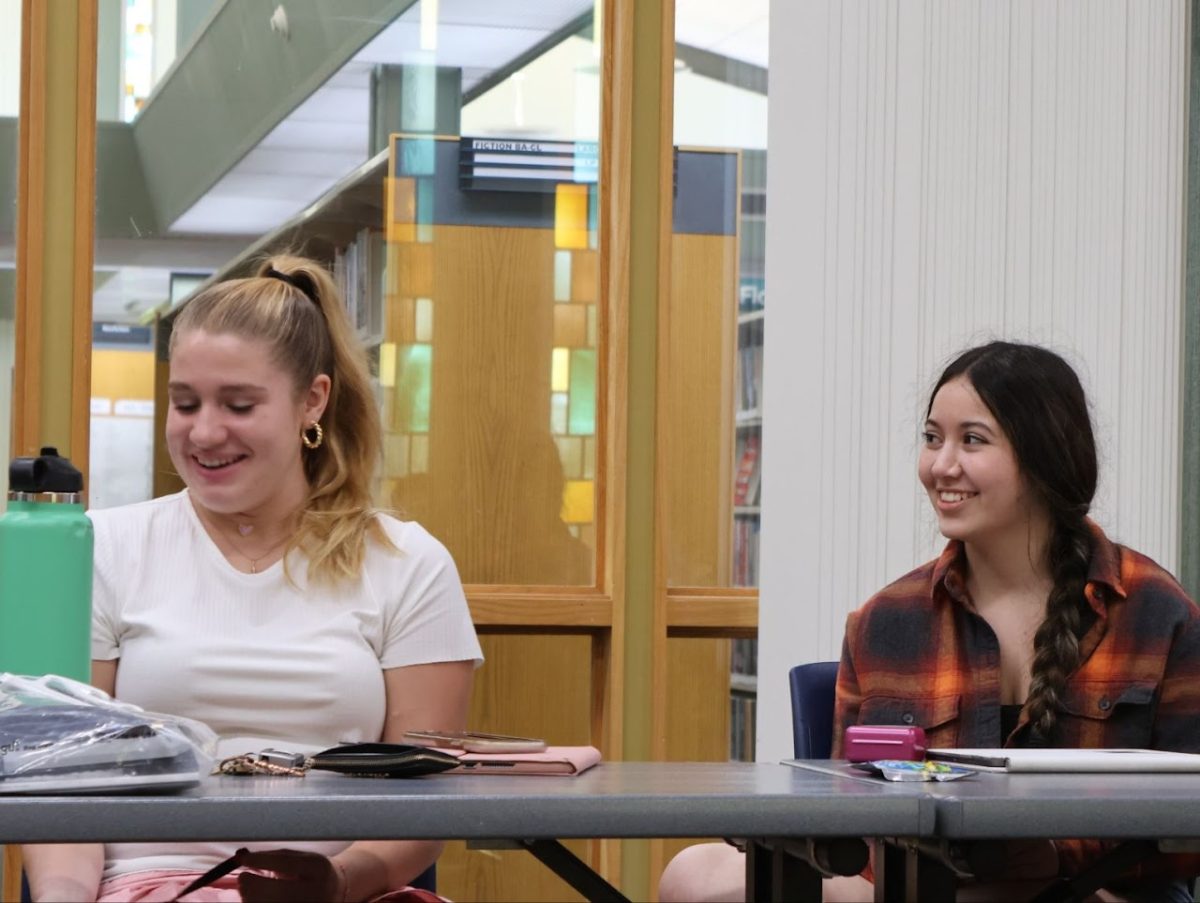 Senior Charlotte Waldo and junior Bridgy McCollum listen to people share at a writer’s workshop.