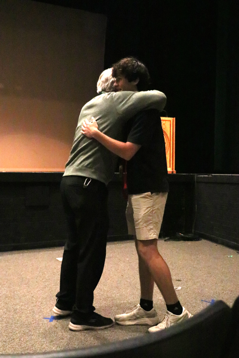 Principal Morton hugging a student after giving him his red cord. Students needed 300 hours of Christian service to receive a red cord.