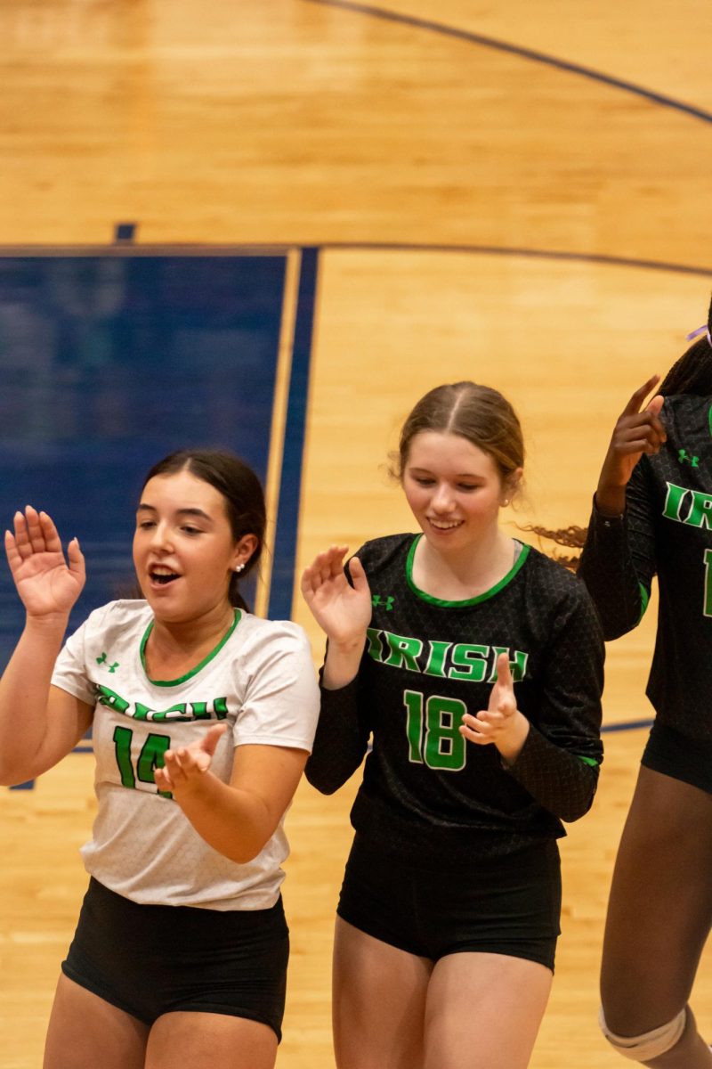 Sohpomore Kenzie Smith and freshman Abby Buckelew clap to a cheer while heading into a timeout at the state tournament.