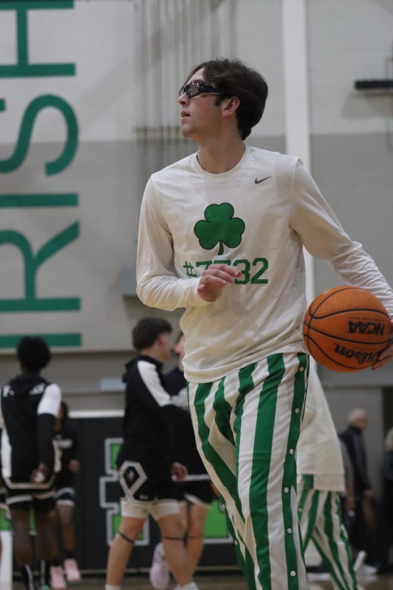 Senior Bryce Schwartz warms up with the team before game against Bishop Lynch January 18. Photo by Molly Taylor
