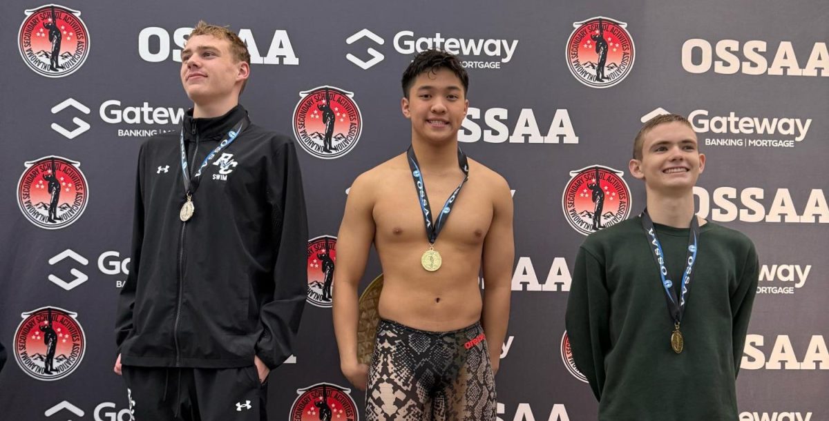 Junior John Nguyen stands on the podium after receiving his medal for his first place finish.