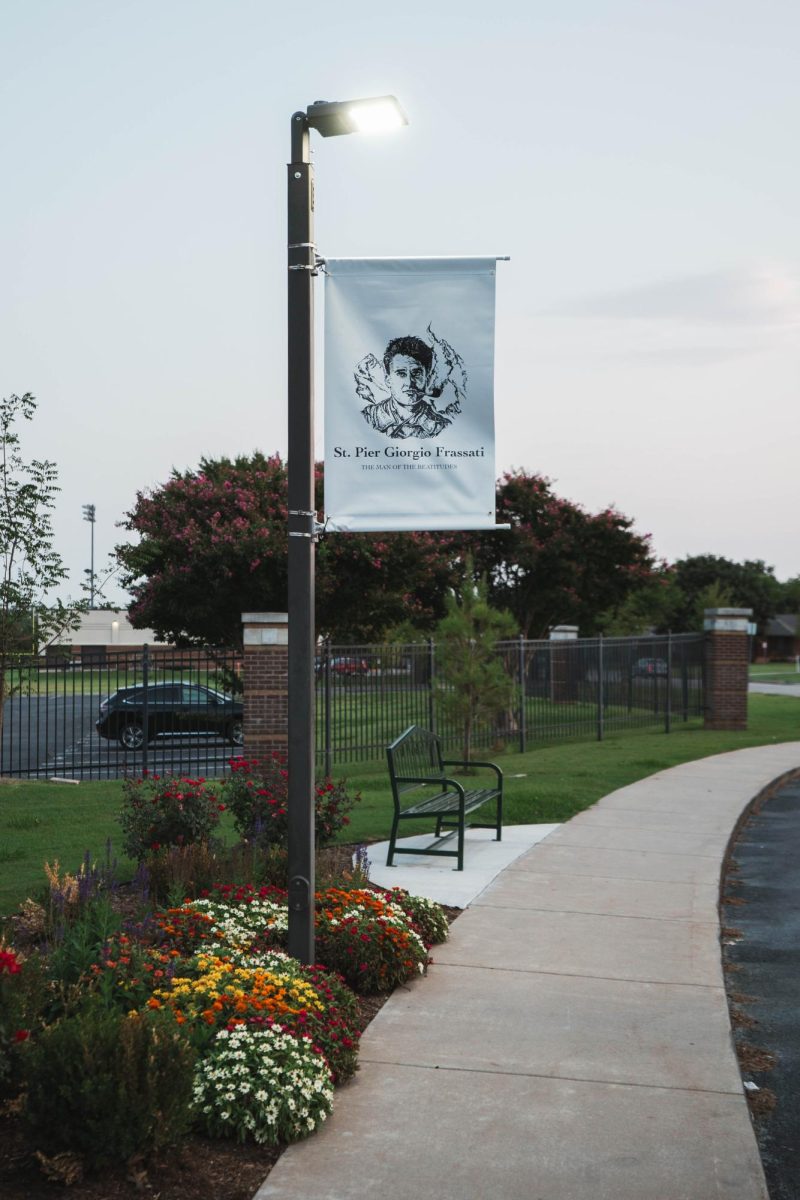 A banner featuring Pier Giorgio Frassati is displayed in front of the school.