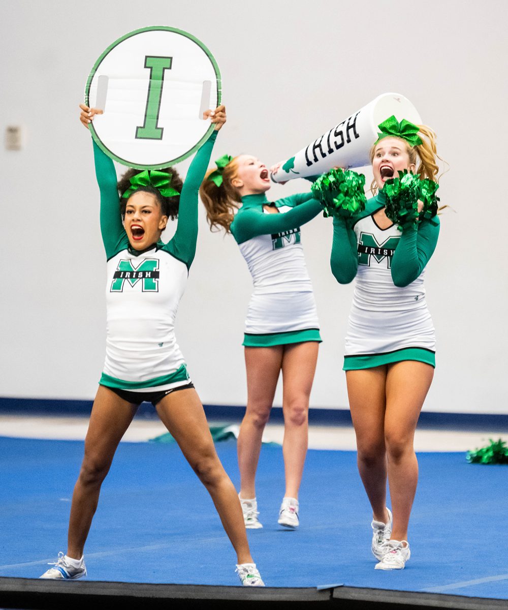 Sophomore Ellen Covington (middle) performs during Cheer Regionals.