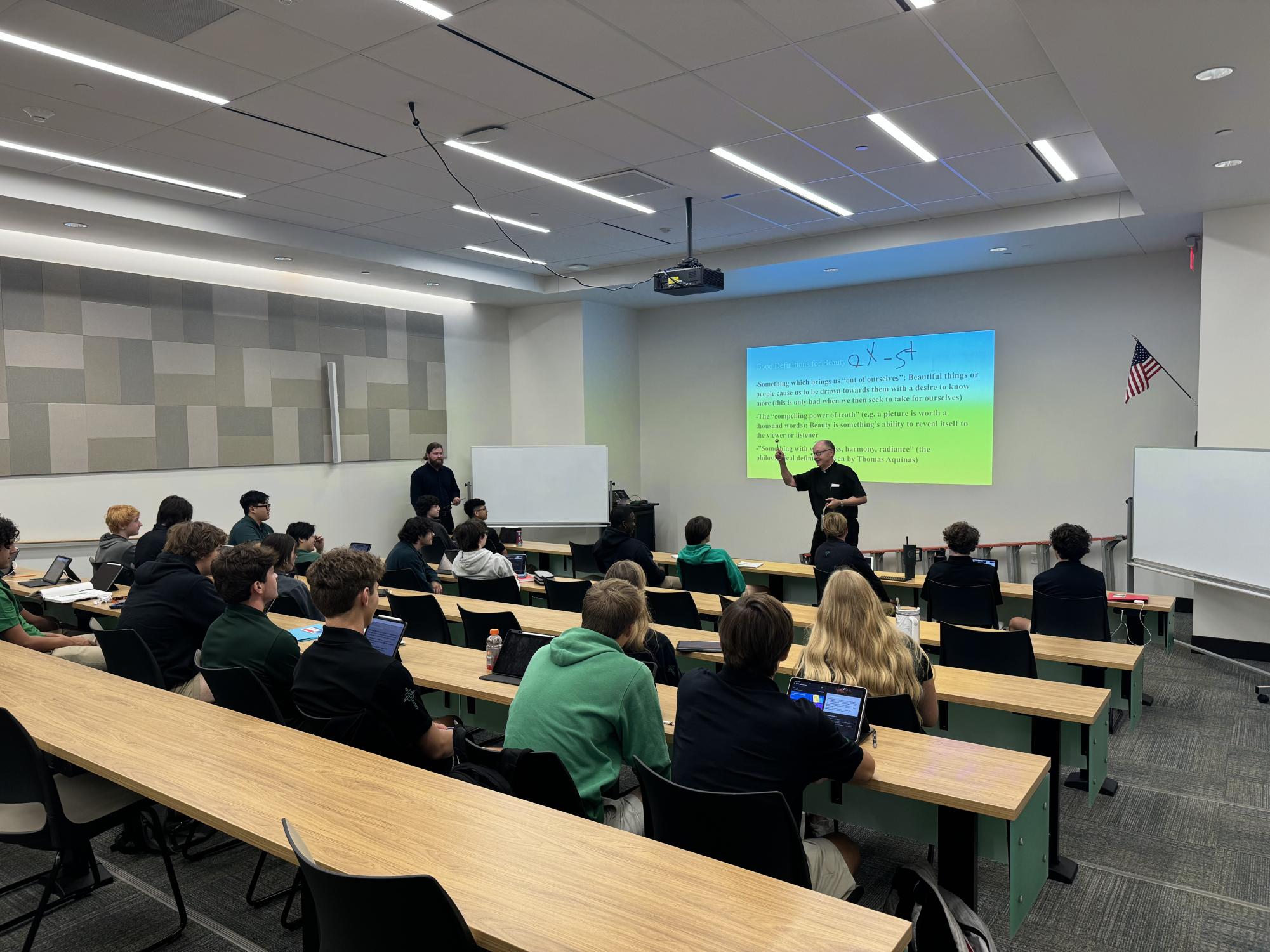 Father Rick Stansberry blesses a class led by theology teacher Gabe Vanness.