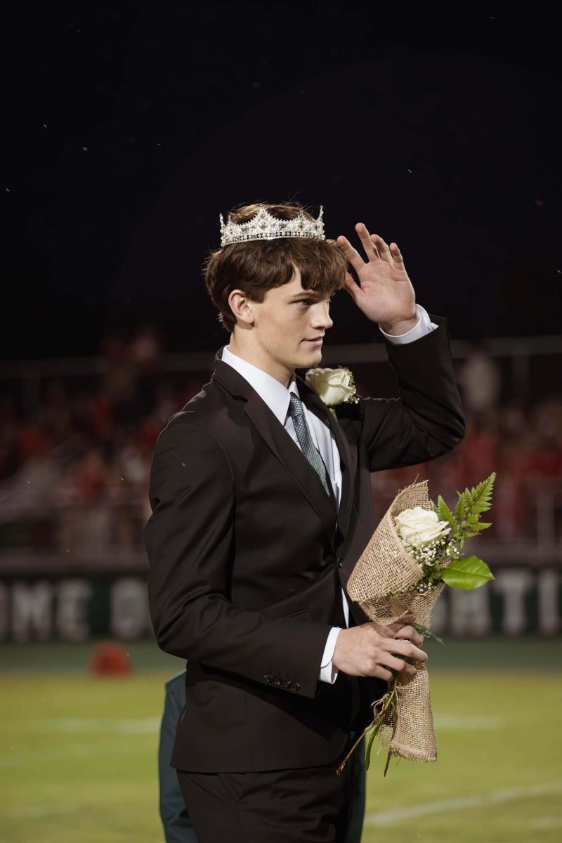 Senior Seth Lucky adjusts his crown after becoming the first homecoming king in school history.