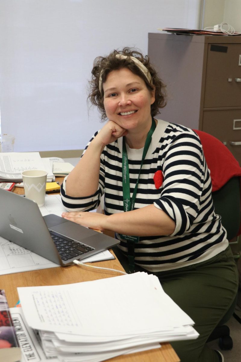 English Teacher Abby Williamson smiles for a photo at her desk.