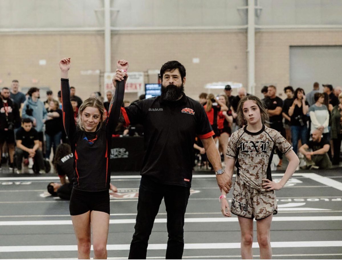 Sophomore Nora Thompson raises her arm in celebration of a win. Photo courtesy of Nora Thompson
