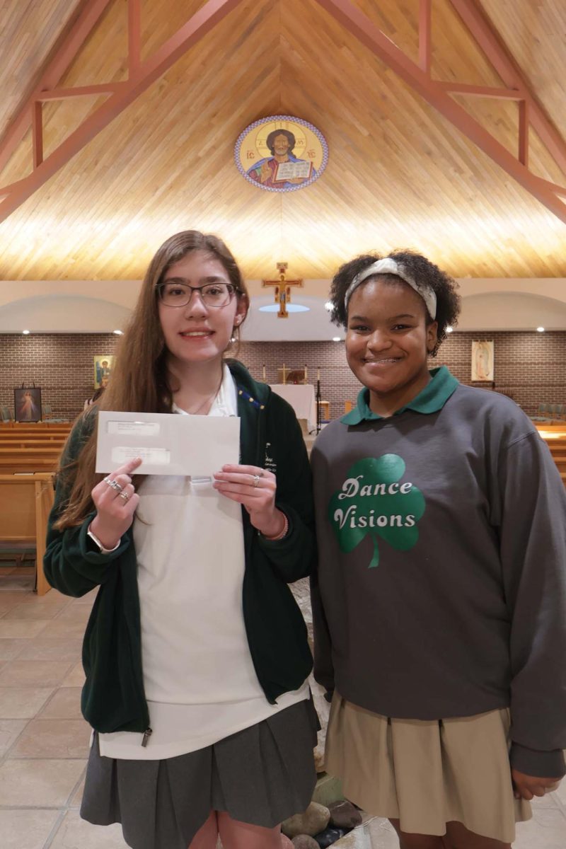Junior Sara Adams and senior Dalayja Armstrong pose for a picture with Adams' first paycheck.