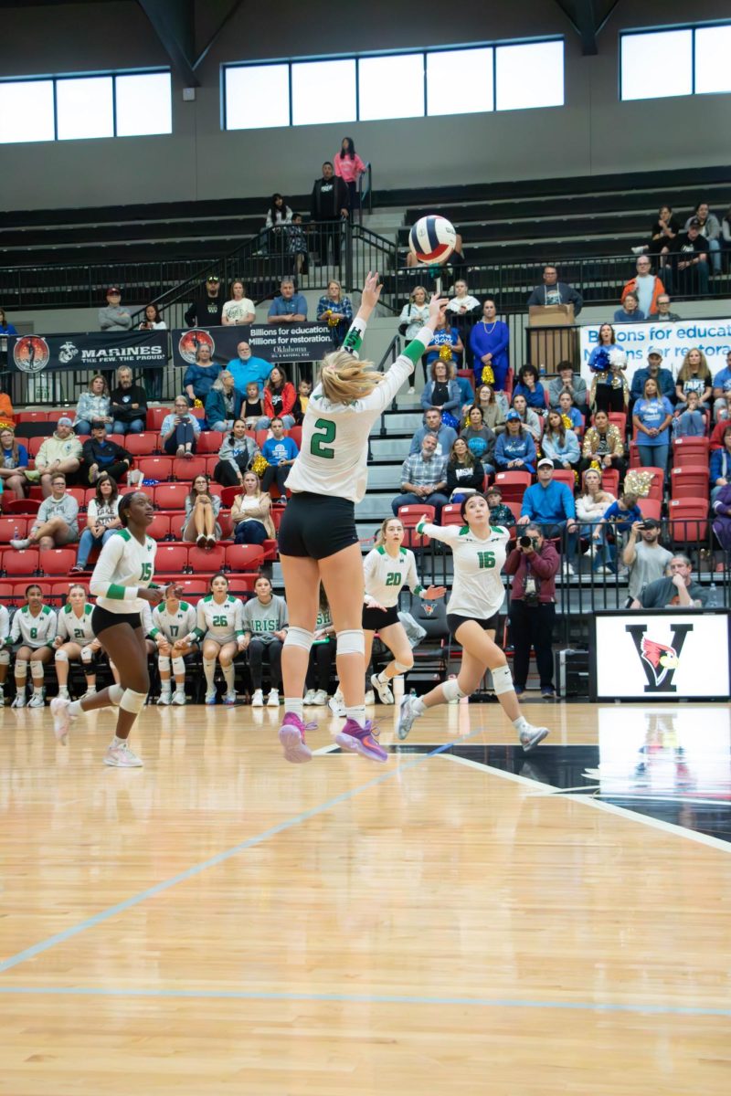 Sophomore Abby Buckelew sets up junior Maggie Loporto for the kill.