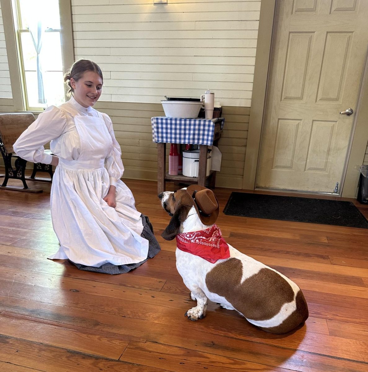 Sophomore Clara Ferate and her dog Henry take photos for the Edmond Wood Room Territorial School House's Instagram account. "We've only done this once, and it went well," Ferate said. "I was trying to get him to sit with a treat so we could get a photo of him with a slate." Photo courtesy of Clara Ferate  